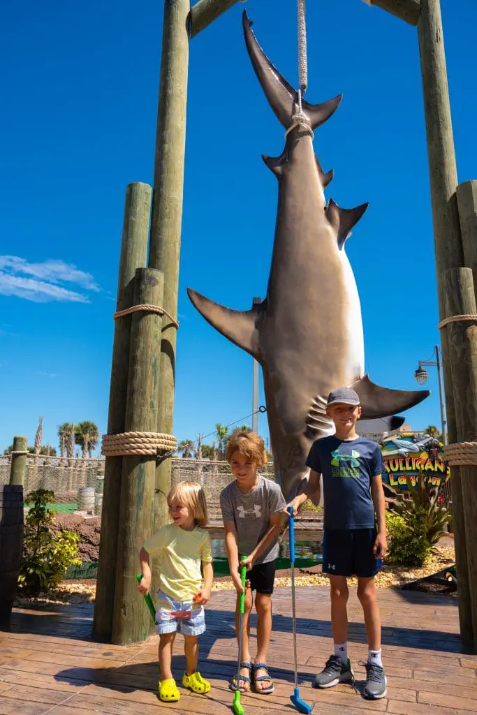 kids in front of a shark at mini golf