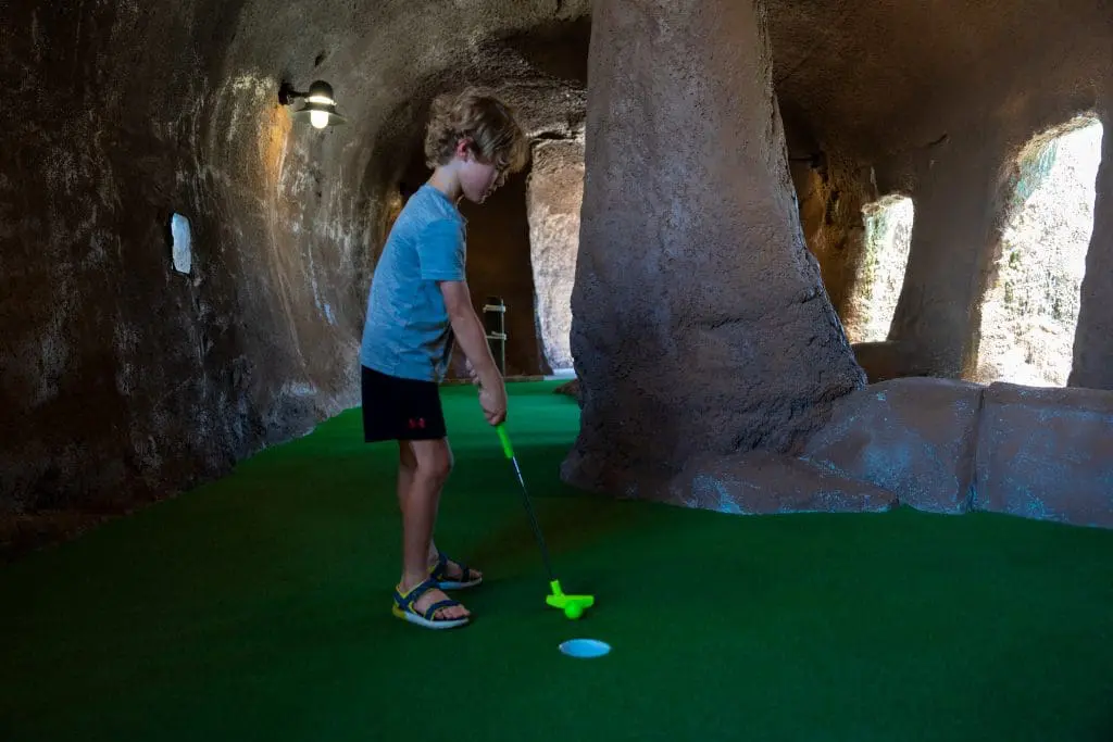 kid playing mini golf
