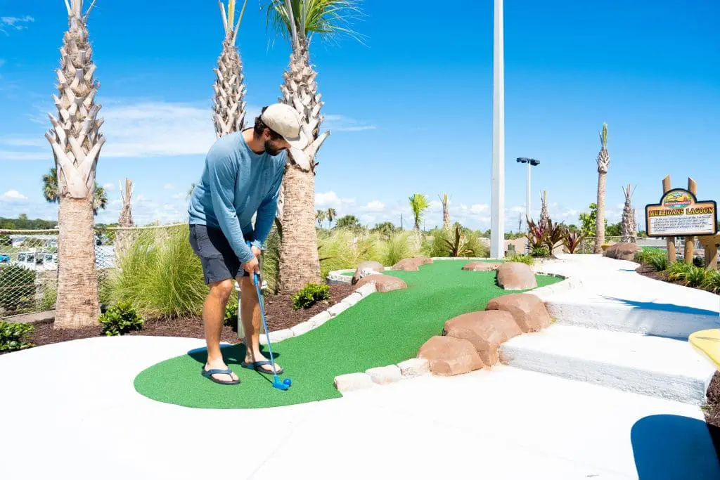 man playing mini golf