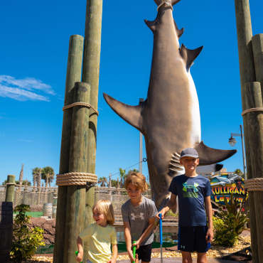 kids in front of a shark at mini golf