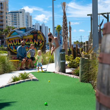 Family playing mini golf