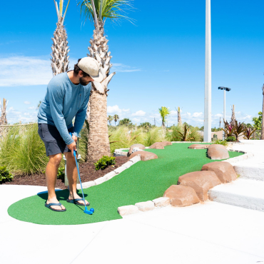 man playing mini golf
